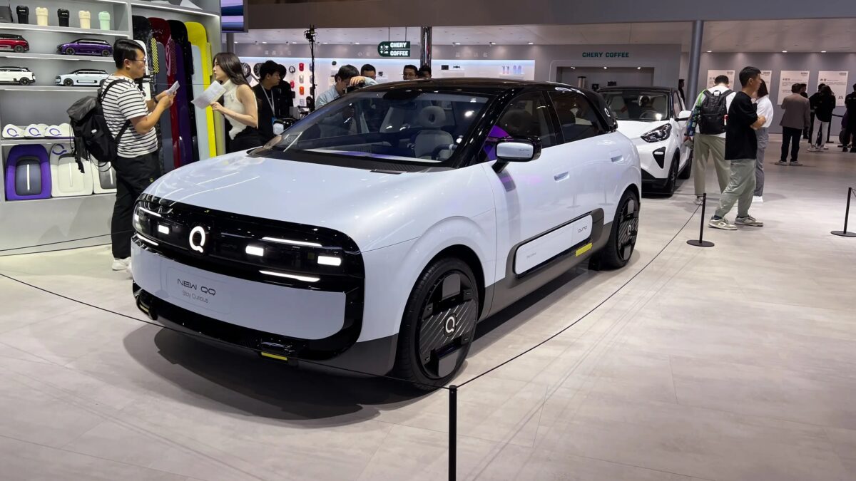 Электрический автомобиль Chery QQ на выставке, передняя часть с светодиодной головной оптикой и декоративной решеткой