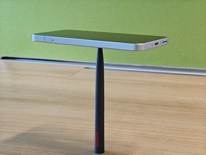 oneplus 13t balanced on a pen