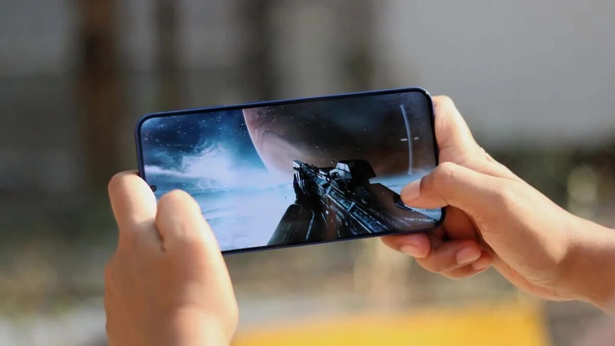 Геймплей на смартфоне Samsung Galaxy S26 с футуристическим оружием и космическим пейзажем