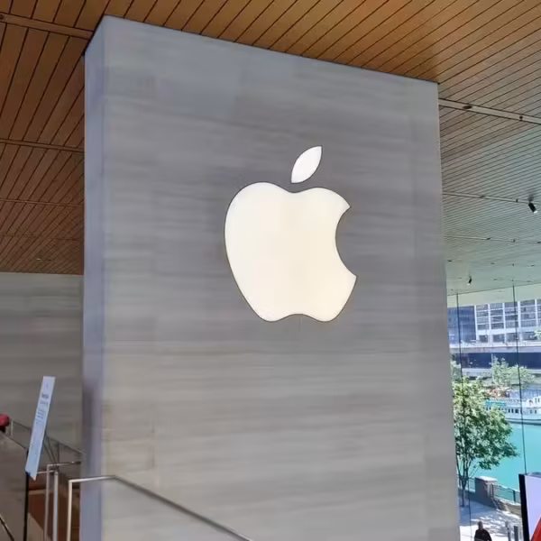 Крупный логотип Apple на стене в интерьере офисного здания в пространстве компании