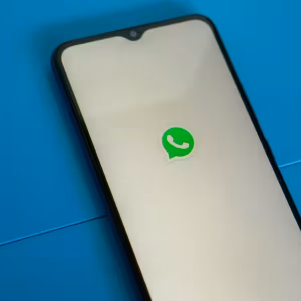 Экран смартфона с логотипом WhatsApp на голубом фоне иконки мессенджера