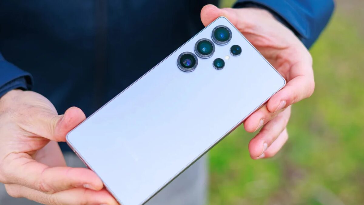 Белый смартфон Samsung с четырьмя задними камерами в руках человека