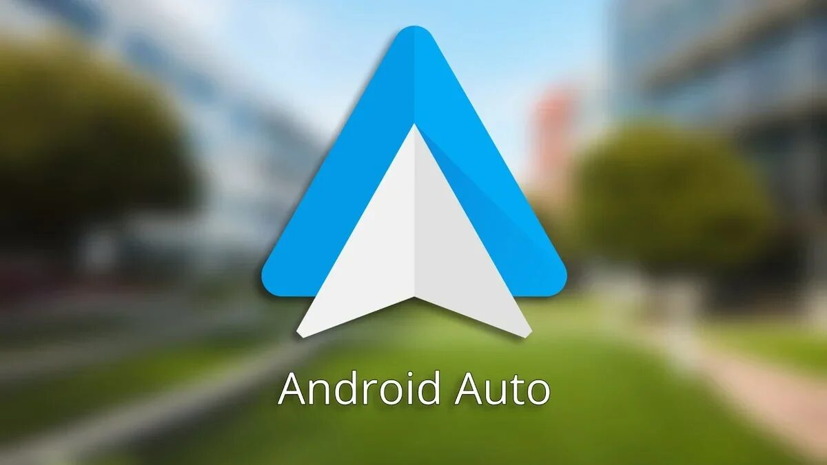 Логотип Android Auto на размытом фоне дороги и деревьев в обновлённом дизайне