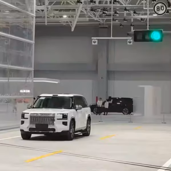 Geely на испытательной площадке центра тестов безопасности: автомобиль на дорожной арене с зеленым светофором