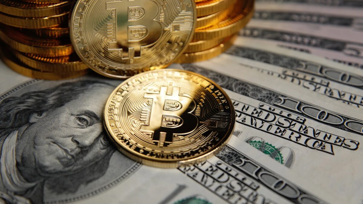 Биткоин и американские банковские купюры на столе