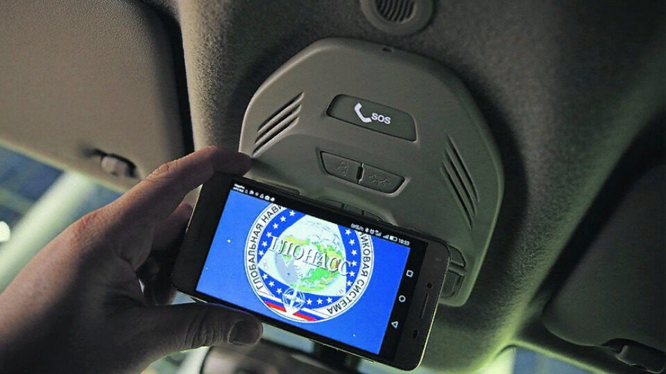 Устройство ЭРА-ГЛОНАСС в салоне автомобиля рядом с навигатором, GPS и автоматическим вызовом