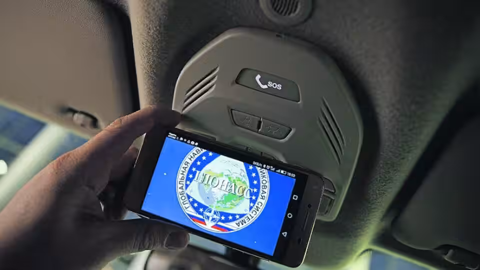 Устройство ЭРА-ГЛОНАСС в салоне автомобиля рядом с навигатором, GPS и автоматическим вызовом