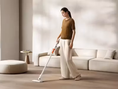 Женщина пользуется лёгким вертикальным пылесосом Xiaomi Mijia в гостиной