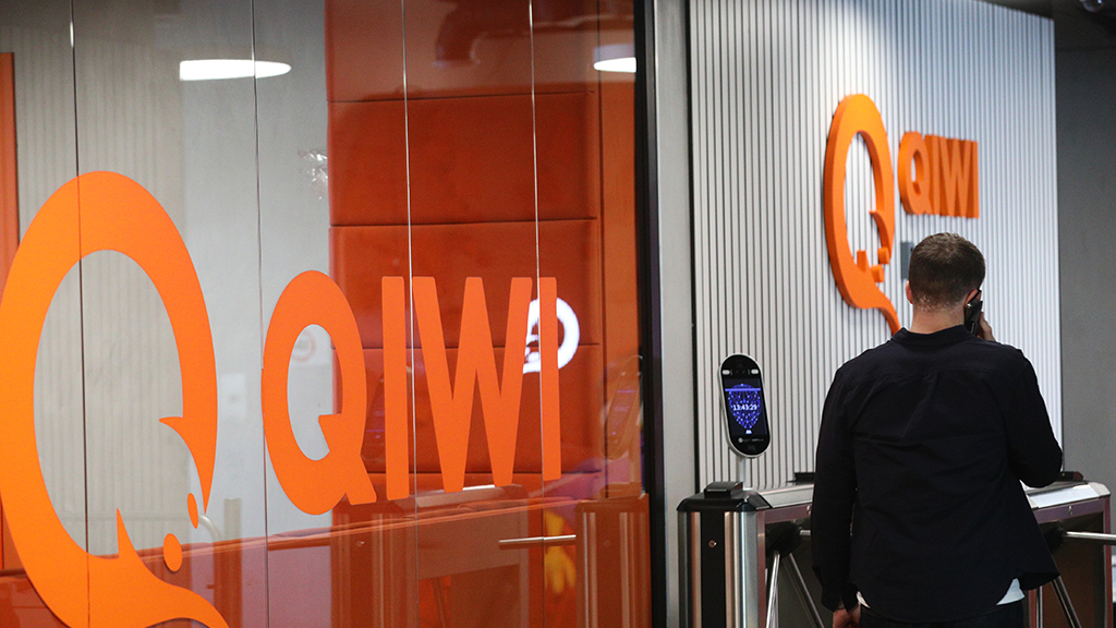 Мужчина обслуживается у терминала Qplus банка Евроальянс, разговаривает по телефону