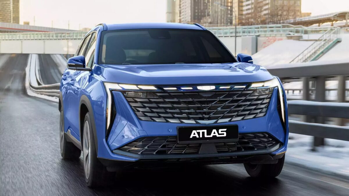 Синий кроссовер Atlas едет по городскому проспекту с современным дизайном