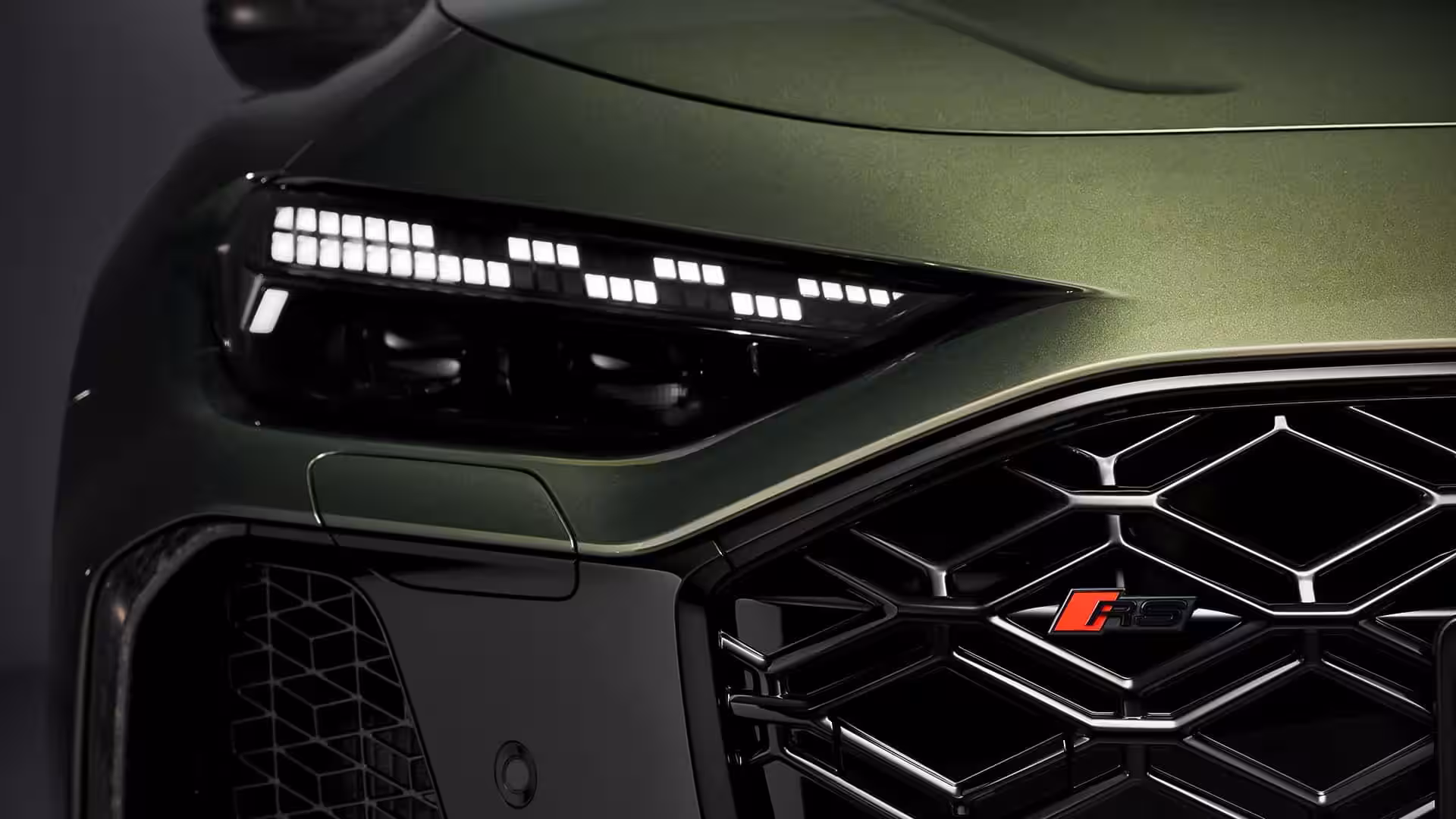 Передняя часть автомобиля Audi RS с решеткой радиатора и фарами