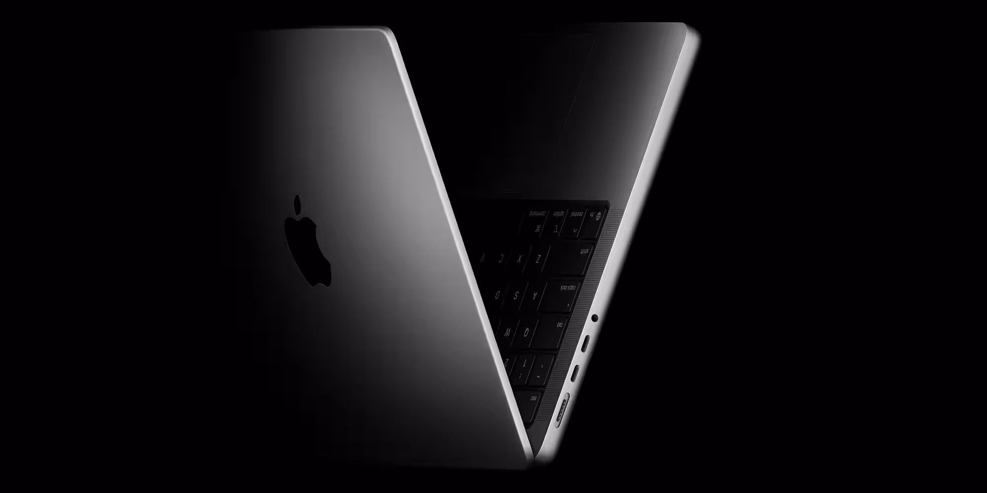 Новый серебристый MacBook с тёмным экраном и портами