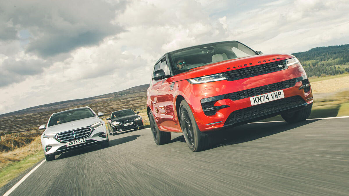 Три автомобиля Range Rover едут по дороге на фоне пейзажа в движении