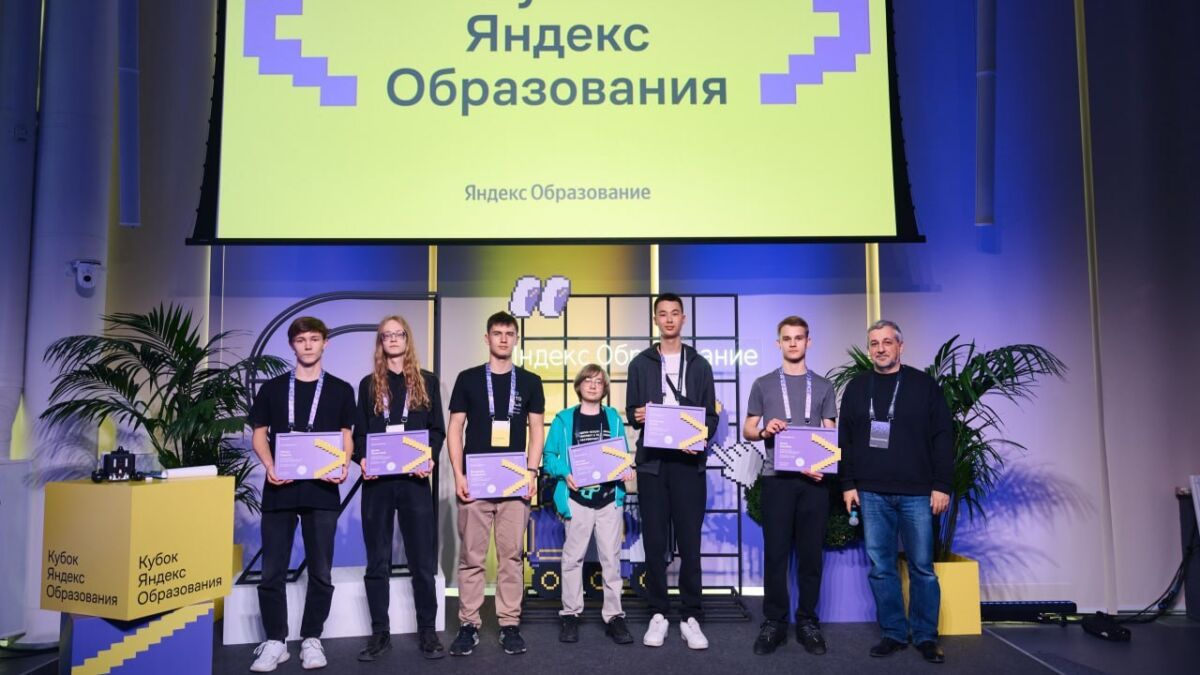 Группа участников и наставник на сцене с дипломами Яндекс Образование
