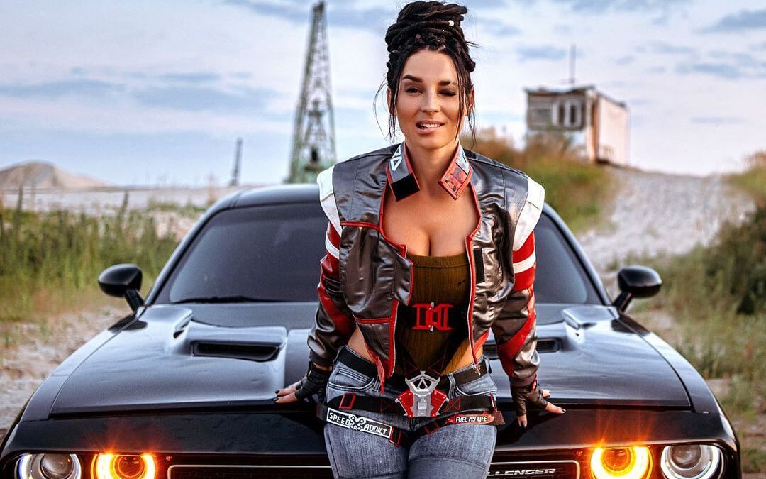 Косплей Панам Палмер из Cyberpunk 2077 у автомобиля с яркими воротниками и металлическими деталями