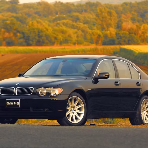 Черная BMW 745i E65 на дороге в движении на фоне сельской местности