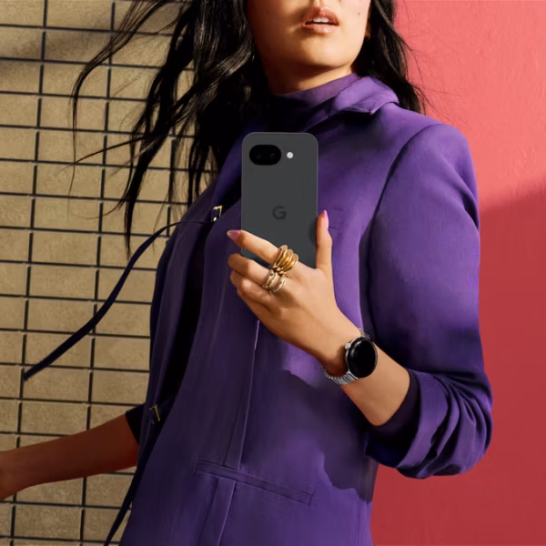 Женщина в пурпурном костюме держит смартфон Google Pixel 7a