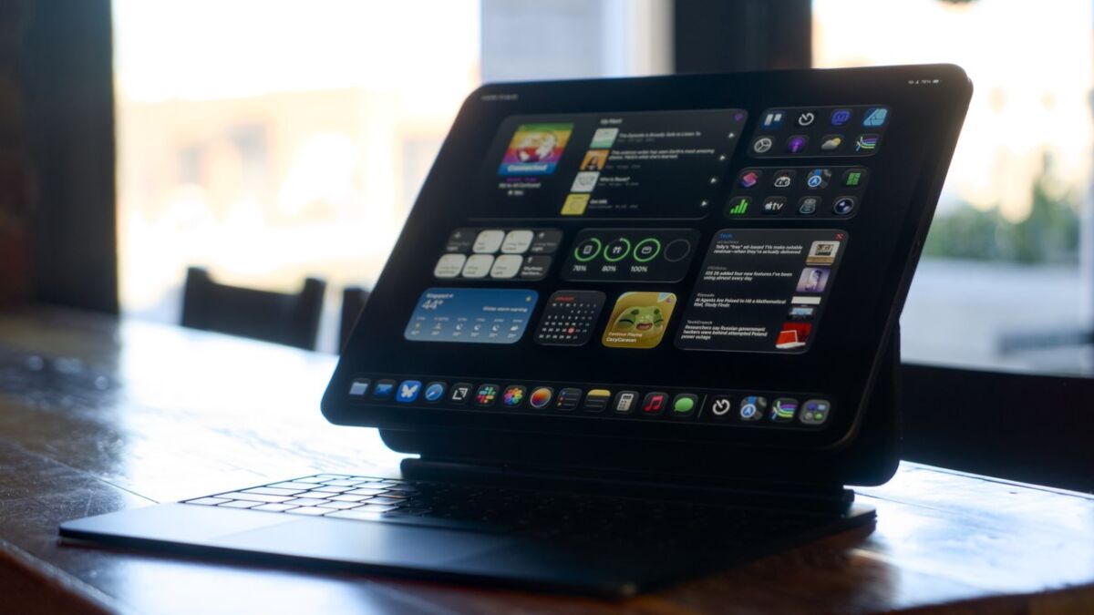 iPad Pro с Magic Keyboard на столе, на экране iOS 18.7.7 и macOS 15.7.5 после обновлений