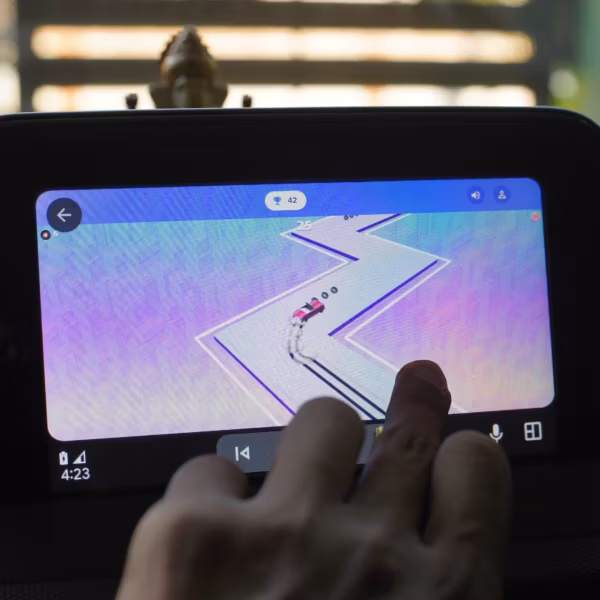 Экран Android Auto показывает игру с машиной на пешеходной дороге