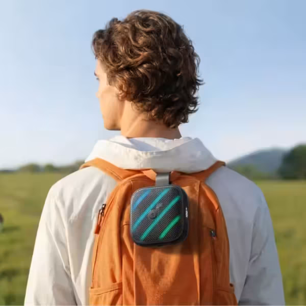 Человек с рюкзаком и портативной колонкой Soundcore Boom Go 3i на плече