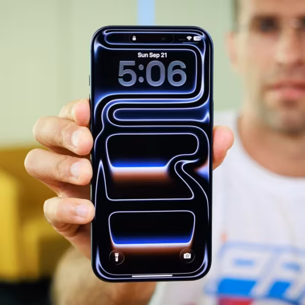Мужчина держит iPhone с эффектом Liquid Glass