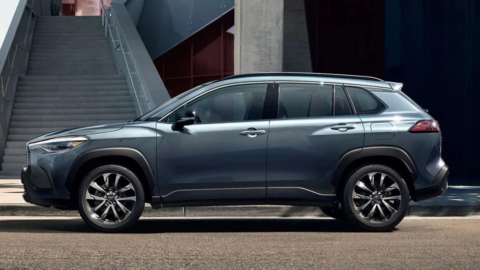 Современный серый кроссовер Toyota Corolla Cross с черными колёсными дисками и большими окнами
