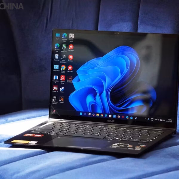 Ноутбук Asus Zenbook 14 OLED на кровати в темной комнате