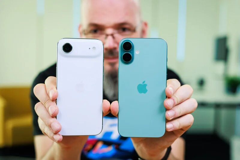 Человек держит iPhone 13 и iPhone 14 Plus на переднем плане