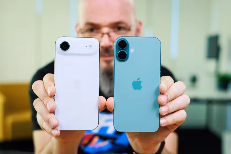 Человек держит iPhone 13 и iPhone 14 Plus на переднем плане