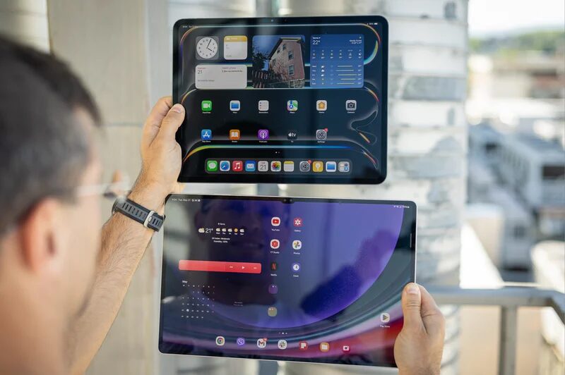 Человек держит iPad и MacBook Neo — сравнение устройств в обзоре за $599