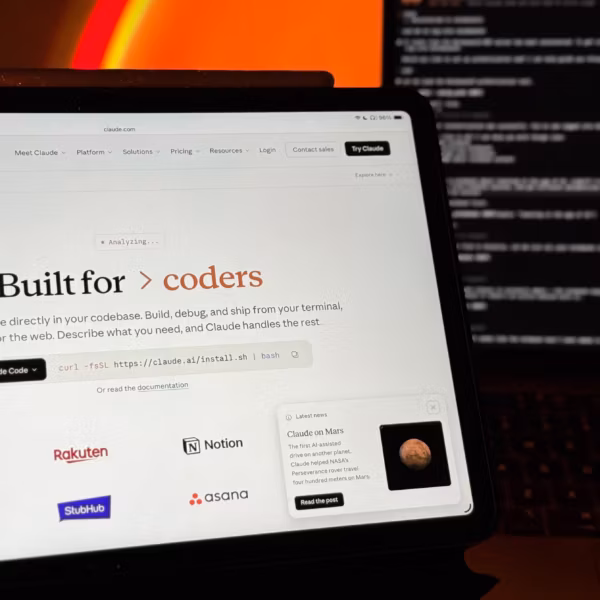 Планшет с сайтом Claude на экране MacBook