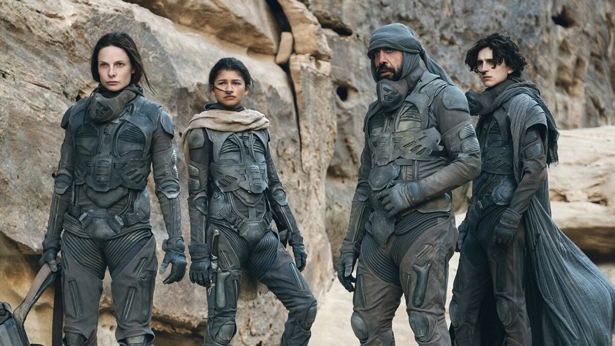 Группа персонажей в фантастических костюмах на каменистой местности