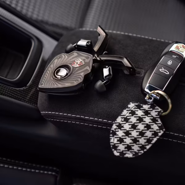 Ключи Porsche T10 Bespoke с тканевым брелоком и карбоновым дизайном на черной поверхности
