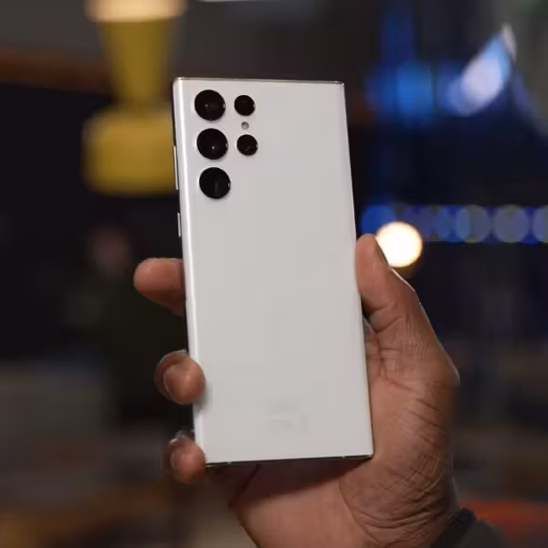 Белый смартфон Samsung Galaxy S22 с четырьмя камерами задней панели