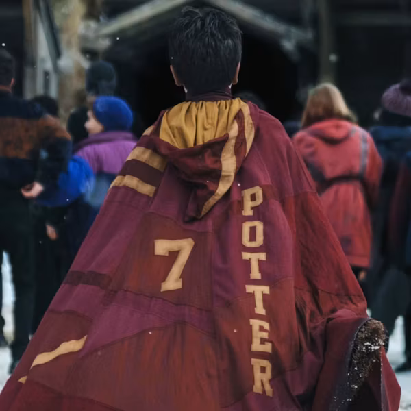 Кадр с людьми на улицах города и человеком в плаще Гарри Поттера в ролике HBO