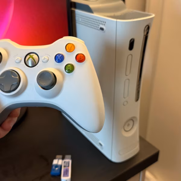 Ручка и контроллер Xbox с цветными кнопками у консоли Xbox Series X