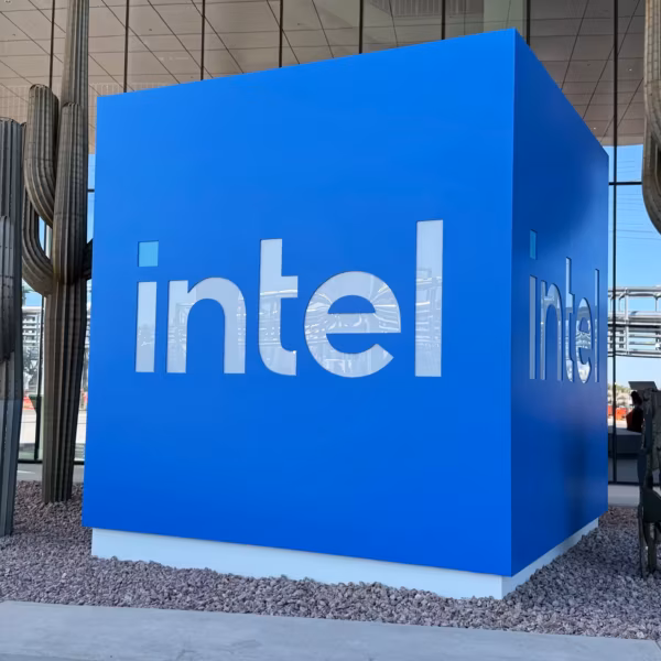 Выставочный стенд Intel с логотипом на синем фоне и синей квадратной стелой