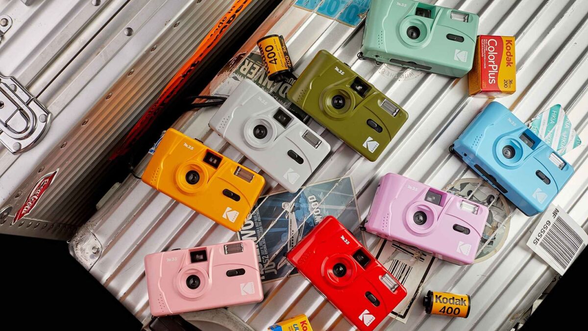 Пленочные камеры Kodak M35 разных цветов лежат на металлической поверхности