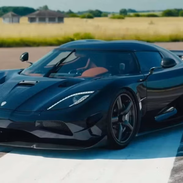 Красивая черная гиперкар Koenigsegg на треке с аэродинамическим обвесом