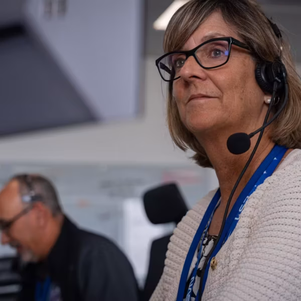 Дженнифер Лайонс в наушниках и очках NASA у комплекса KSC в кадре NASA Warner Bros