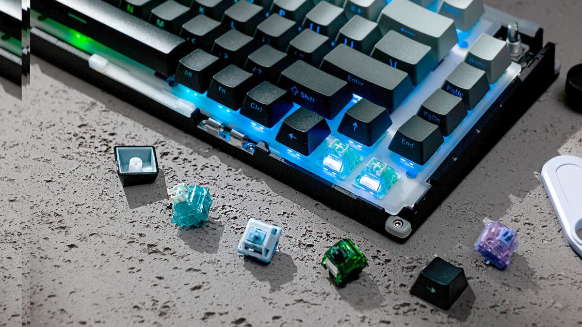 Клавиатура с TMR-переключателями и разбросанными с синими и белыми переключателями на столе