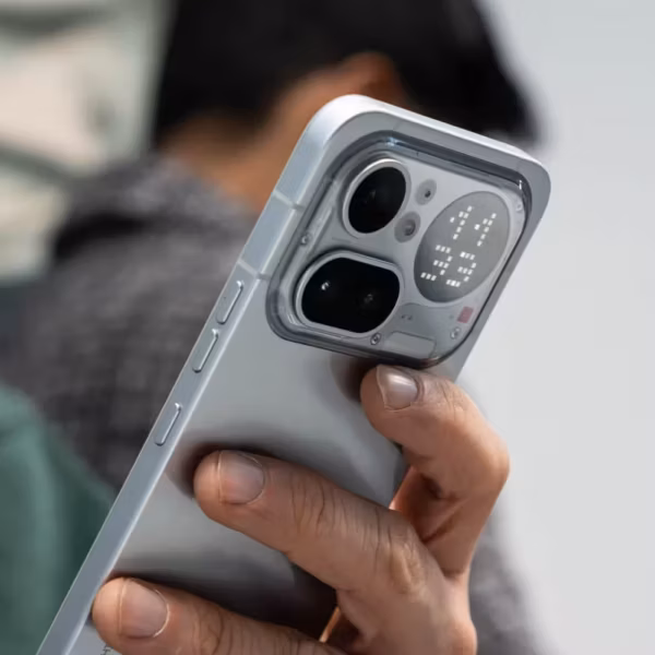 Владелец держит iPhone с прозрачной крышкой Nothing Phone 4a Pro и дисплеем на задней панели