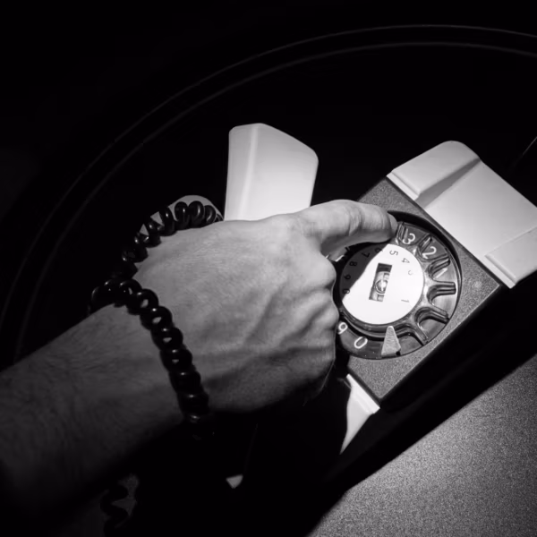 Рука человека нажимает на телефон для госзакупок