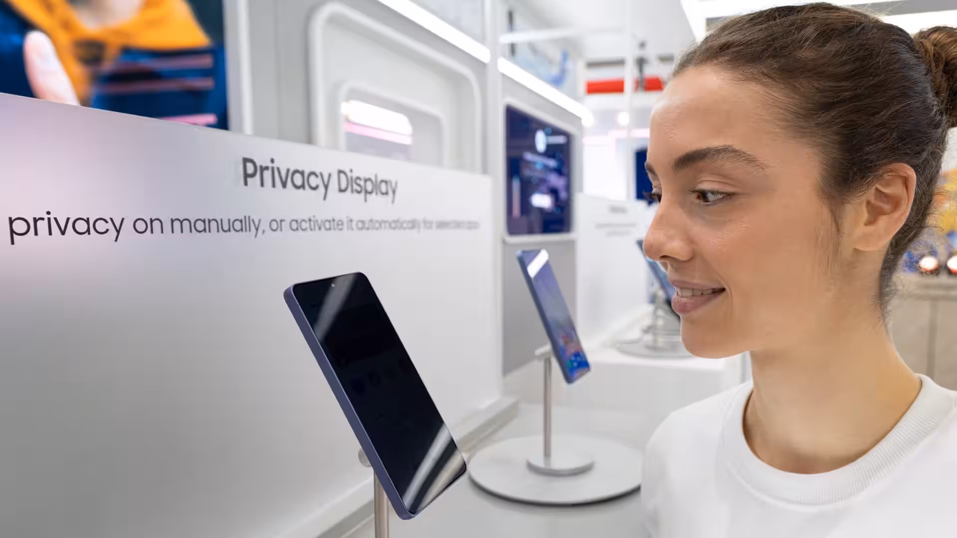 Девушка смотрит на смартфон Samsung OLED в магазине