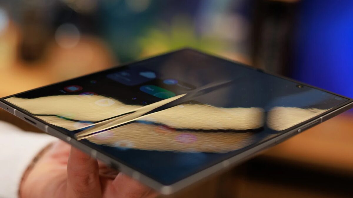 Складной iPhone в руке с демонстрацией изменённого дисплея в сравнении с Galaxy Z Fold 7