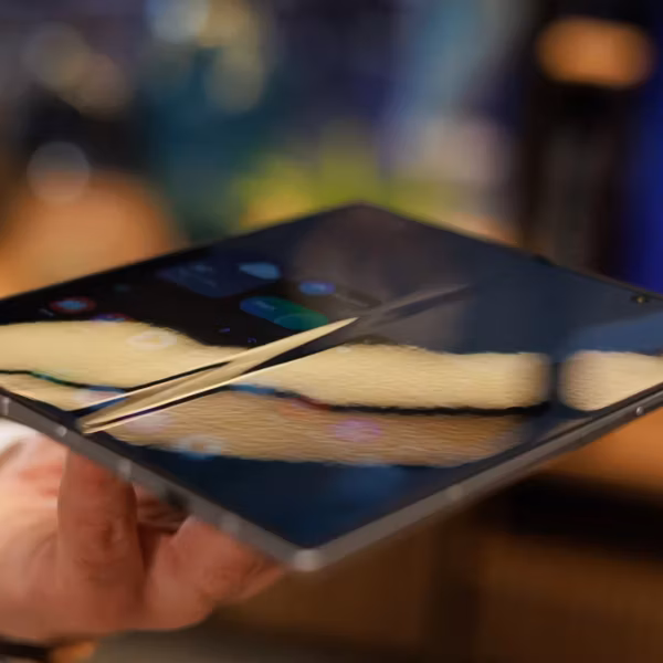 Складной iPhone в руке с демонстрацией изменённого дисплея в сравнении с Galaxy Z Fold 7