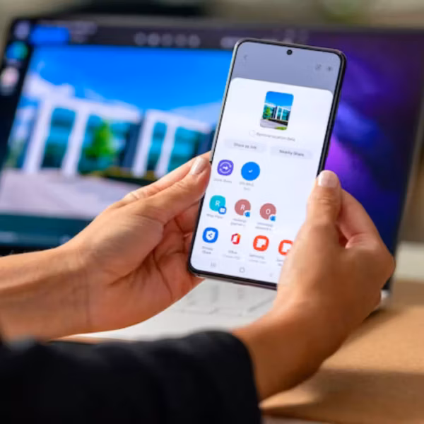 Человек держит смартфон Samsung Galaxy S26 с поддержкой Quick Share и AirDrop