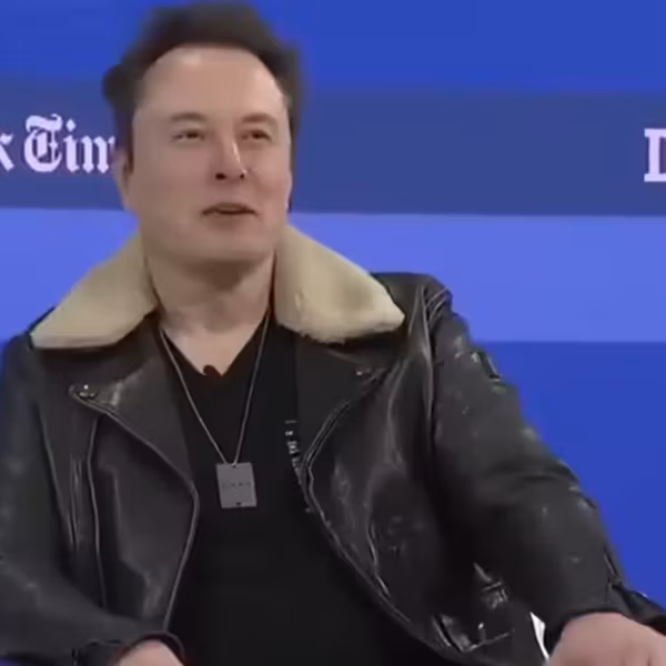 Мужчина рядом с панелью логотипов Tesla и xAI, упоминание цифрового Optimus на базе AI4