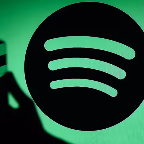 Логотип Spotify на зеленом фоне с теневым силуэтом руки на иконке приложения