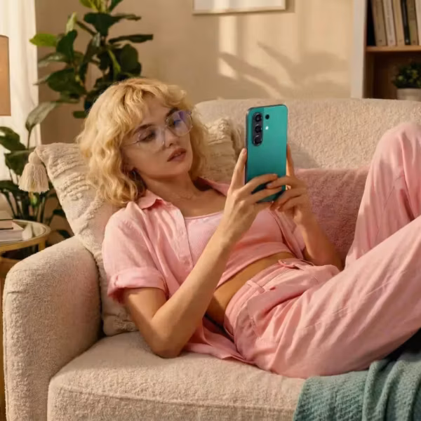 Женщина в очках держит смартфон Tecno Prime 5, T2 запускает тариф с безлимитным доступом к ИИ